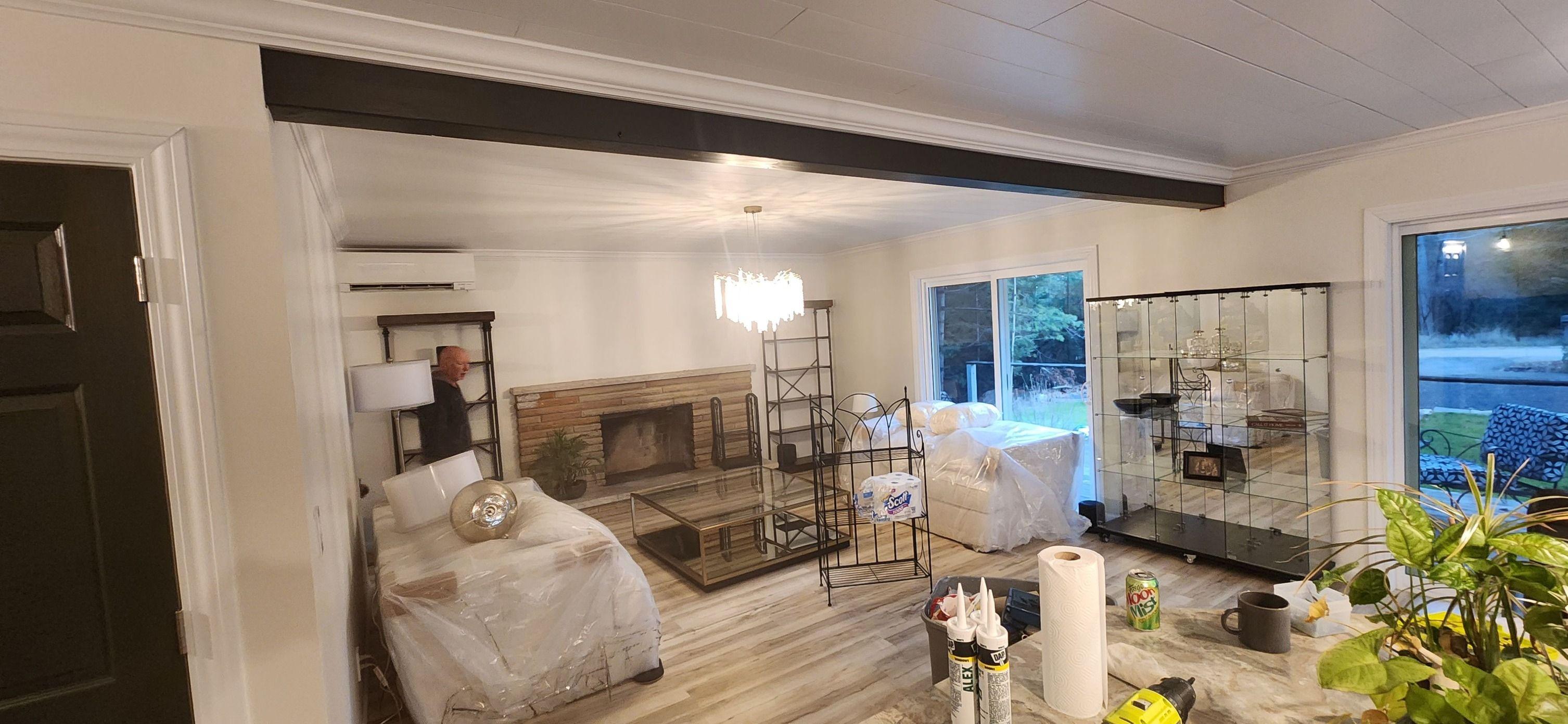 Painted crown molding, doors, and wooden beam in Forest Lake, MI living room
